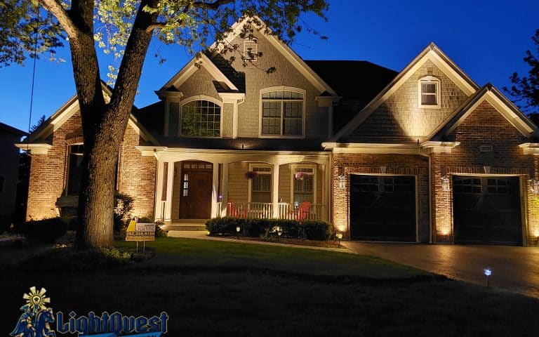 Luxury residence with architectural landscape lighting highlighting columns and trees for improved curb appeal in Kenilworth, Illinois.